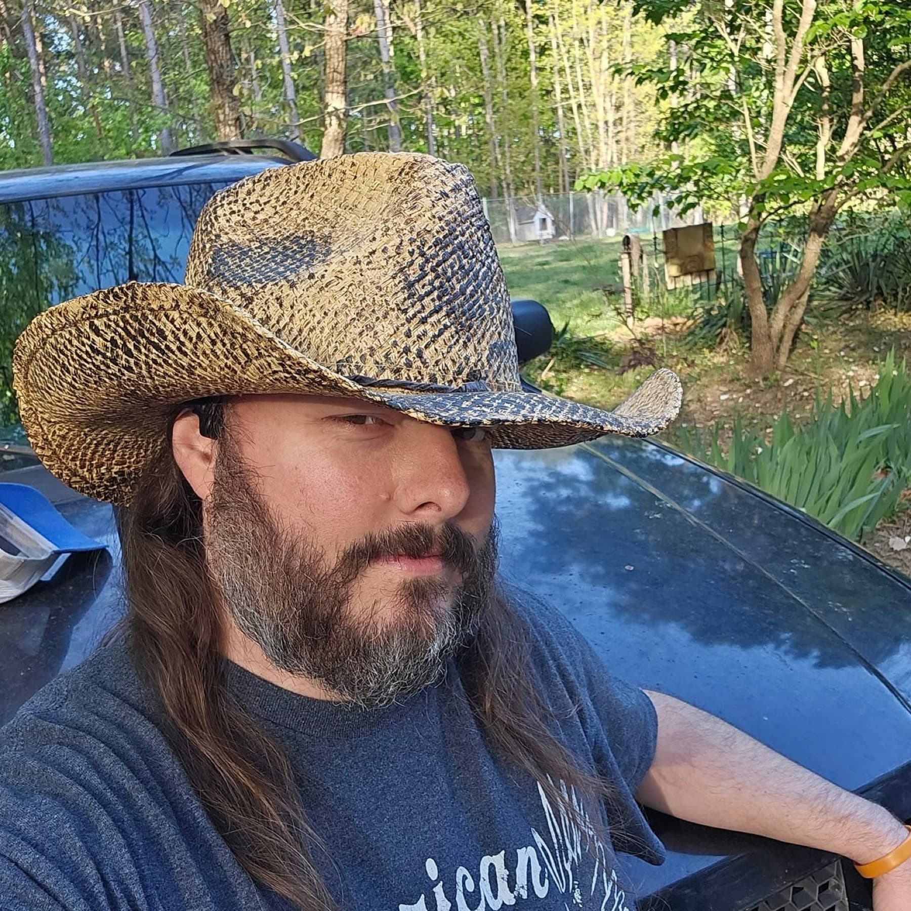 Jawa (JawaMeta) portrait — Shawn in a straw cowboy hat Recent portrait of Jawa (Shawn, @JawaMeta) wearing a woven straw cowboy hat, long hair and beard, leaning on a dark truck